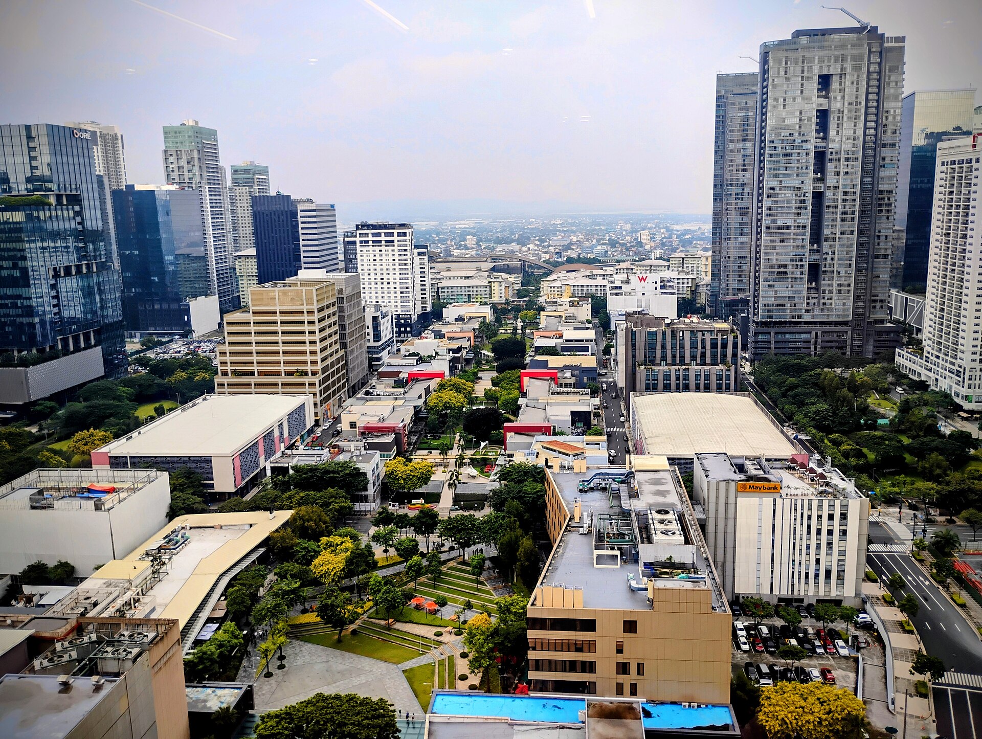 BGC from the Philippine Stock Exchange Tower: high-rises, commercial space, a landscaped central spine, and an ordered street grid unfold within one master plan.