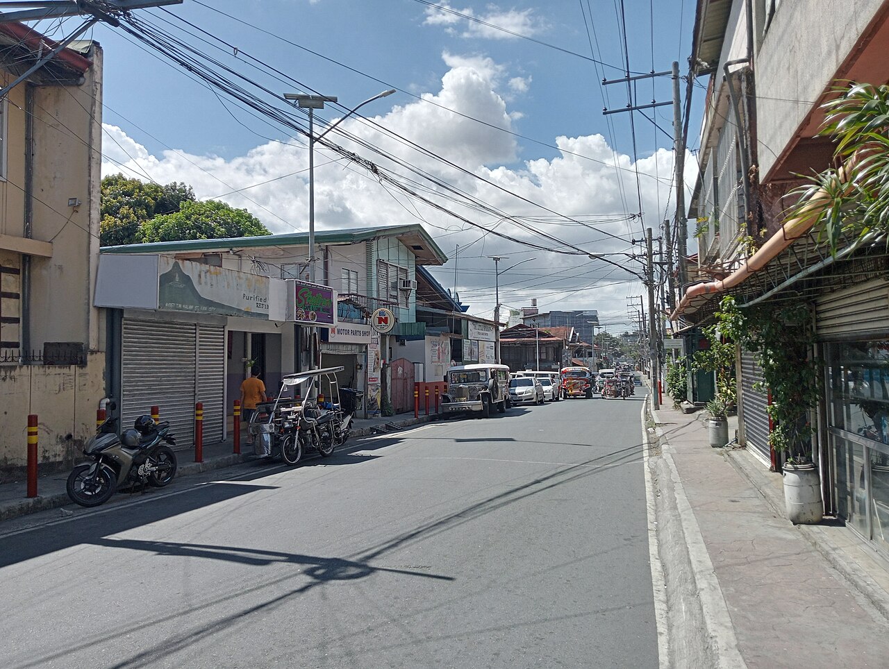 Lipa 市区 T.M. Kalaw Street：一条承载汽车、吉普尼和三轮车等混合交通的城市街道。
